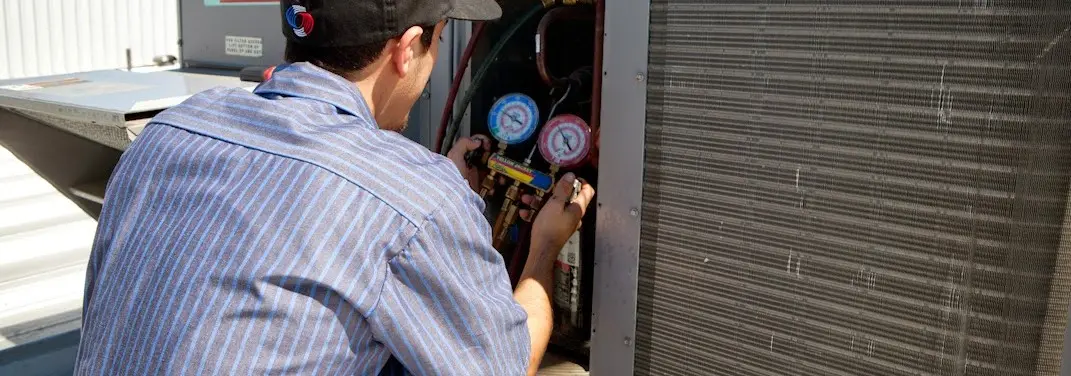 HVAC technician servicing a condenser unit in Mays Chapel